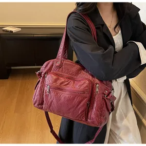 Detailed view of vintage burgundy PU leather tote bag featuring multiple zipper pockets