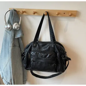 Large capacity black retro PU leather multi-pocket tote bag hanging on wooden rack.