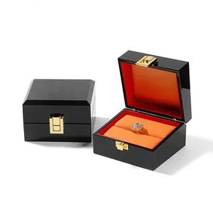 Luxury black lacquer jewelry gift box featuring orange velvet lining and golden clasp