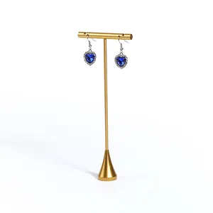 Eleganter goldener T-Schmuckständer aus Metall mit blauen Herzohrringen im Detail