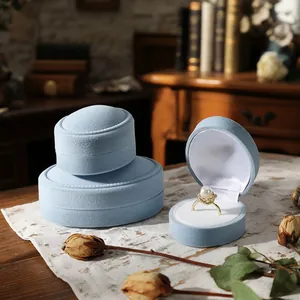 Elegant light blue velvet jewelry box set for rings and pendants on a wooden table