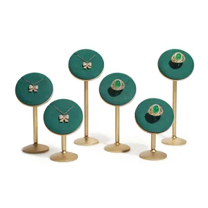 Luxury emerald green velvet jewelry display stands with gold metal bases