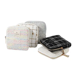 Elegant tweed jewelry organizer pouches with gold zippers in various colors and patterns.