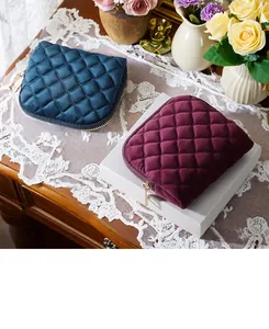 Detalles exquisitos de estuches para joyas de terciopelo acolchado en azul y granate.