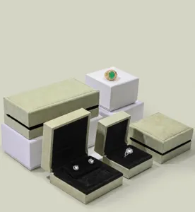 Macro detail of green suede jewelry storage boxes with an elegant black velvet lining.