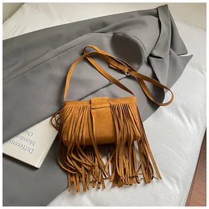 Close-up detail of a vintage brown suede saddle bag featuring long stylish fringes