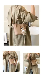 Casual khaki textured bucket bag detail with cute white bear keychain accessory charm