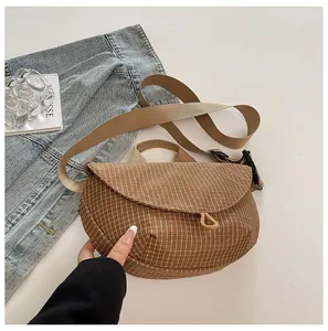 Primer plano de un bolso bandolera casual de lona a cuadros marrón para mujer estilo de vida