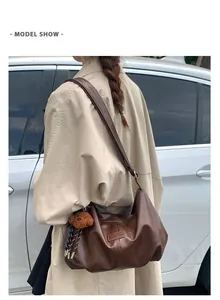 Detailed view of a stylish retro brown pleated large capacity shoulder bag on a model.