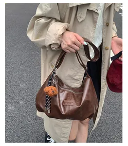 Fashionable brown large capacity pleated hobo bag held by model outdoors