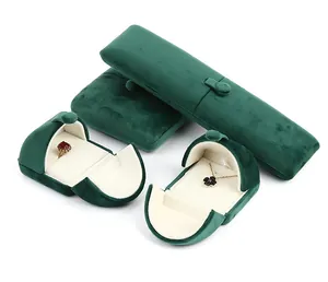 Dettaglio di portagioie in velluto verde scuro con bottoni a pressione e interno morbido.
