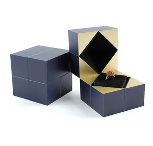 Detalle de cajas de anillos en forma de cubo azul oscuro abiertas y cerradas