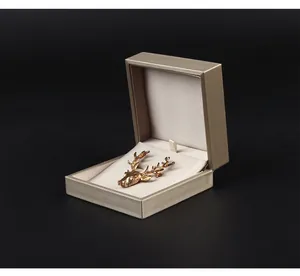 Detailed view of gold deer head brooch inside a square PU leather jewelry gift box