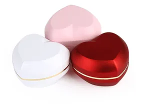 Top view of three elegant heart-shaped jewelry boxes in white, pink, and red colors.
