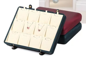 Detailed view of a premium green 12-slot necklace display box with plush beige lining