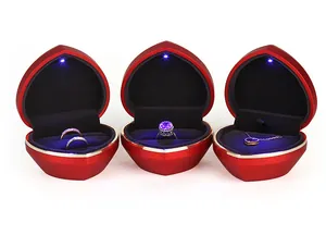 Three red heart-shaped LED jewelry boxes for rings and necklaces on white background