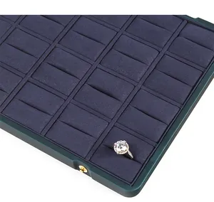 Close-up view of a luxury velvet jewelry display tray with organized ring storage slots