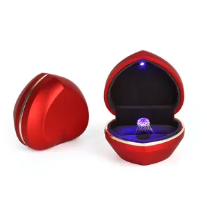 Red heart-shaped jewelry box with built-in LED light for wedding engagement ring.
