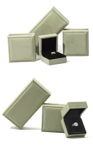 Vista detallada del juego de cajas de joyería de ante verde salvia con los anillos