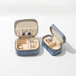 Macro view of portable blue velvet jewelry box showing internal slots and rings
