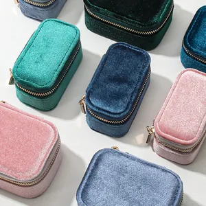 High-angle view of multiple velvet jewelry boxes in pink, blue, and green colors