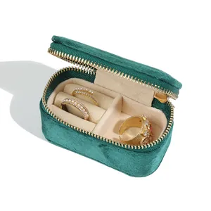 Detail of emerald green velvet travel jewelry box with golden zipper and ring slots