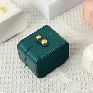 Portable teal green faux leather jewelry box with a secure golden snap button closure
