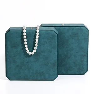 Elegant octagonal teal jewelry box with pearl necklace on white background.