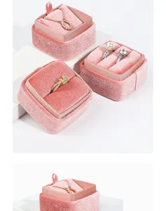 Soft pink velvet jewelry box with ring and pendant slots on white display blocks