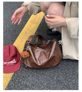 Lifestyle view of a vintage brown pleated shoulder bag with a cute poodle charm