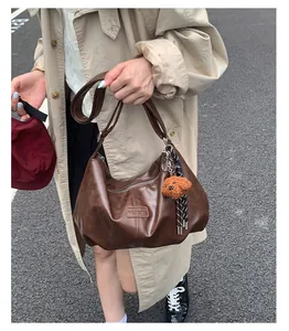 Detailed view of the large capacity pleated brown shoulder bag styled on a fashion model