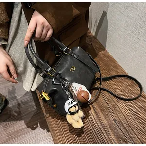 Detailansicht einer schwarzen Boston-Tasche im Vintage-Stil mit Bären- und Basketballanhänger