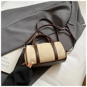 Close-up of frosted cream Boston bag with brown trim on a grey blazer background