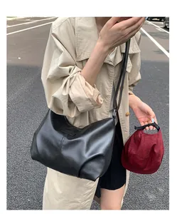 Close-up view of a minimalist black pleated faux leather underarm shoulder bag for commuting