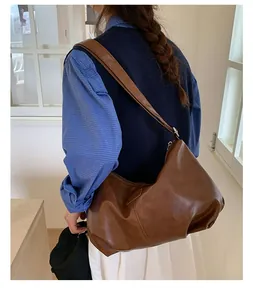 Detailed view of a brown pleated faux leather hobo bag with large capacity for commuting.