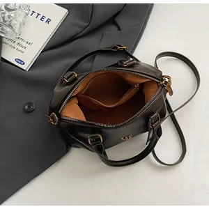 Detailansicht der geräumigen Innenfächer einer braunen Boston-Handtasche aus Kunstleder