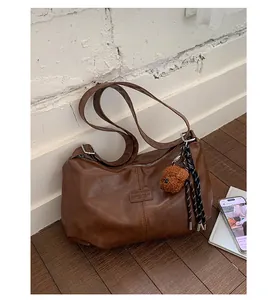 Detail shot of a vintage brown pleated faux leather underarm bag in a lifestyle setting