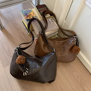 Retro large capacity underarm shoulder bag for commuting with plush bear charm.
