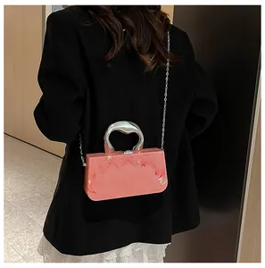 Elegant pink marble acrylic box clutch bag with silver sculptural handle shown on a model