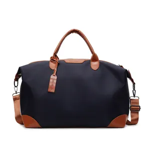 Vue détaillée du sac de voyage bleu marine avec poignées en cuir marron et étiquette.
