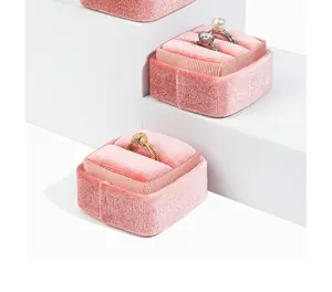 Detailed view of luxury pink velvet ring boxes with elegant striped trim accents