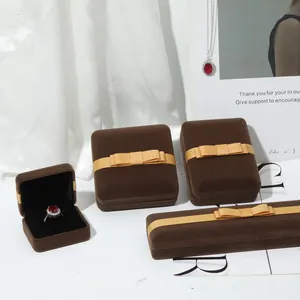 Elegante bruine fluwelen juwelendoos met gouden strik voor ringen en ook armbanden
