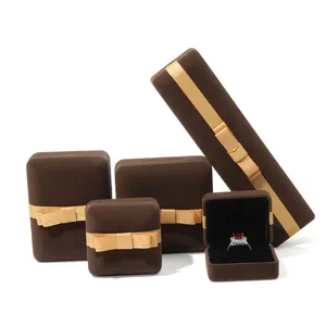 Premium bruine fluwelen sieradendoosset met gouden strik voor ringen en kettingen