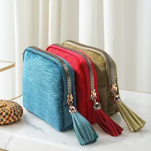 Tassel zipper jewelry storage pouches in multiple colors shown on a marble surface