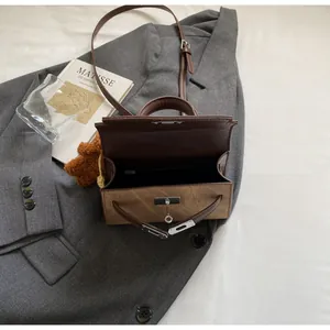 Detailansicht der schicken braunen Handtasche mit Silberverschluss und Innenfutter.