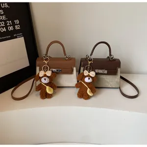 Zwei zweifarbige Handtaschen mit Goldverschluss und niedlichen Teddybär-Anhängern