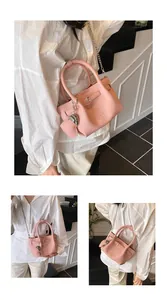 Detailed view of pink lychee grain handbag with chain strap and heart charm