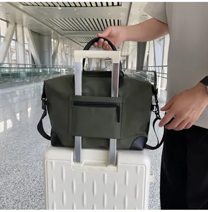 Large olive green travel duffle bag with trolley sleeve shown on a white suitcase