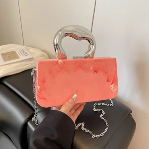 Fashionable pink acrylic marble box bag with a chunky silver handle and chain strap