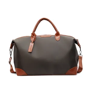 Vue de face d'un sac de voyage olive foncé avec détails en cuir marron et bandoulière